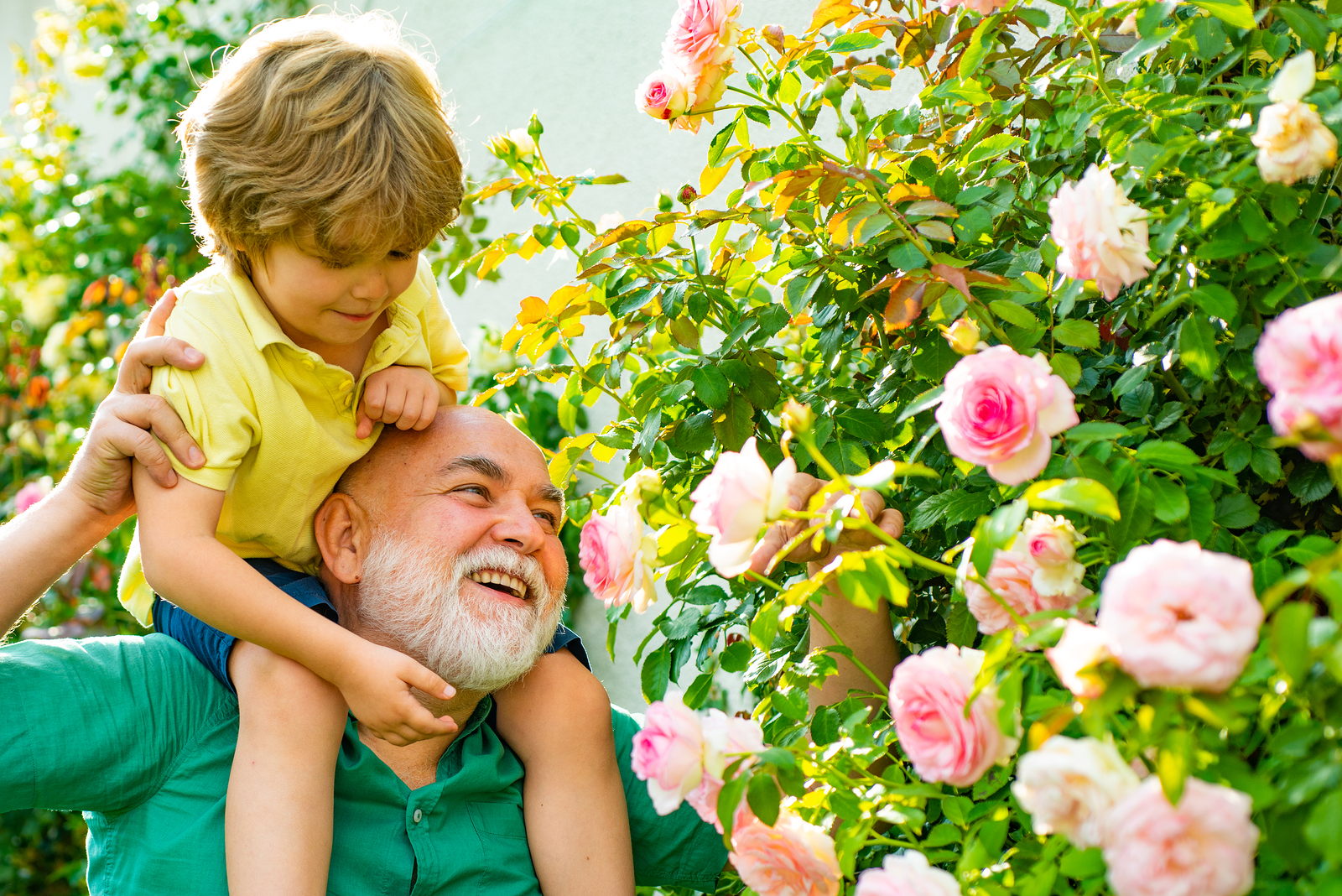 Happy Grandfather Giving Grandson Piggyback Ride On His Shoulder
